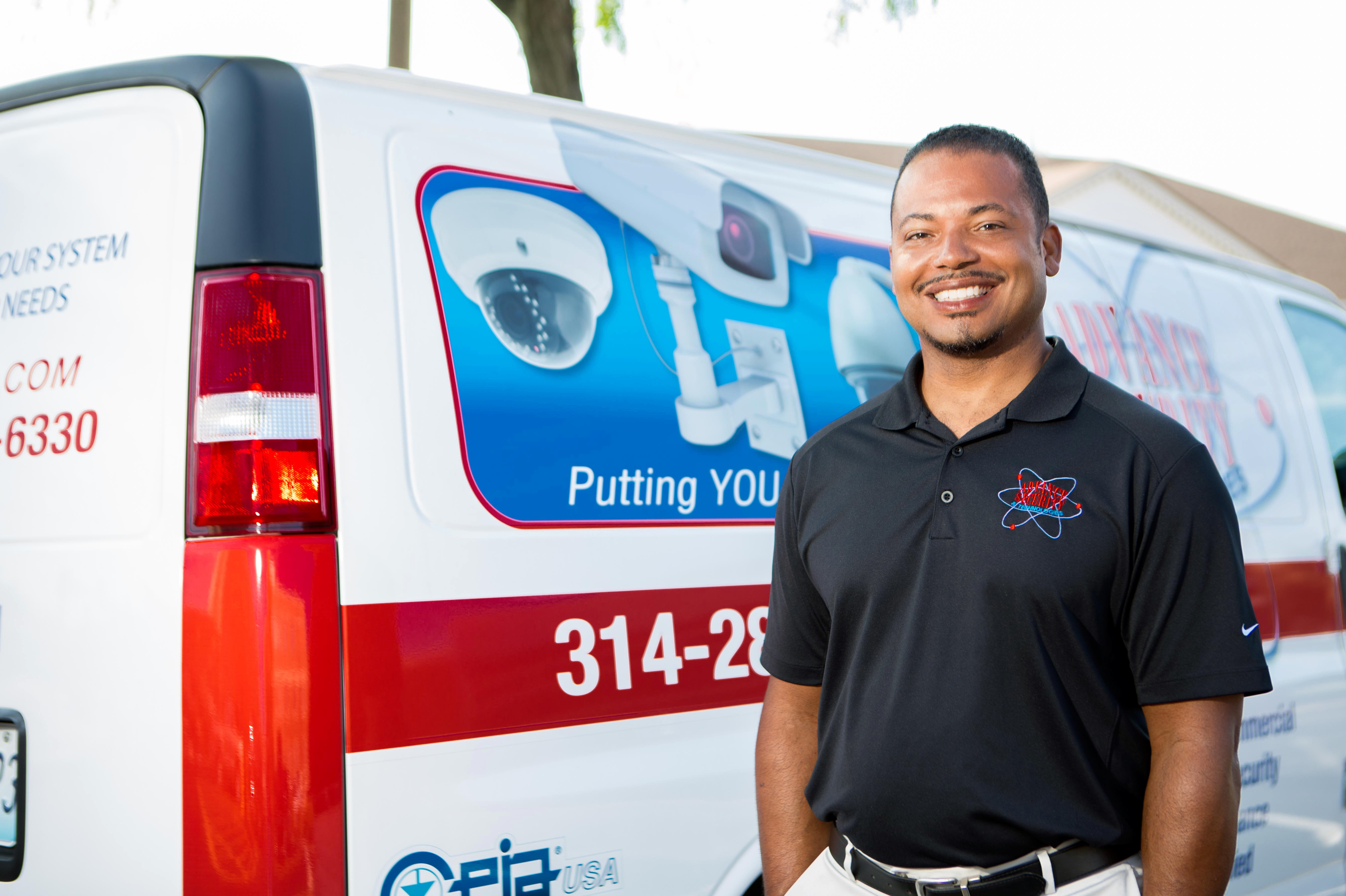 Michael Gillam, owner of Advance Security & Technologies, standing in front of company van